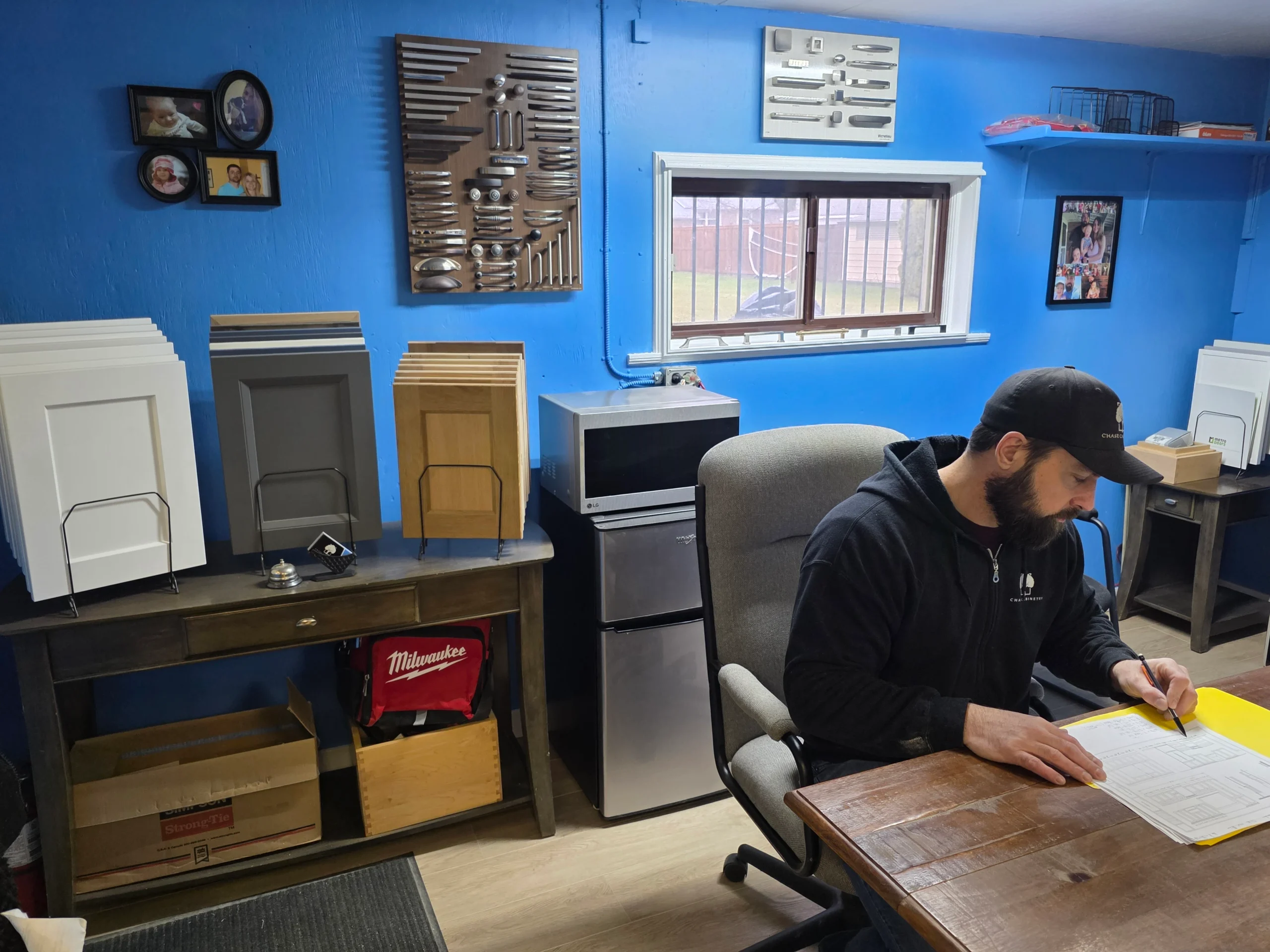 Professional licensed cabinet maker reviewing credentials and project plans in Ontario workshop, trust and professionalism